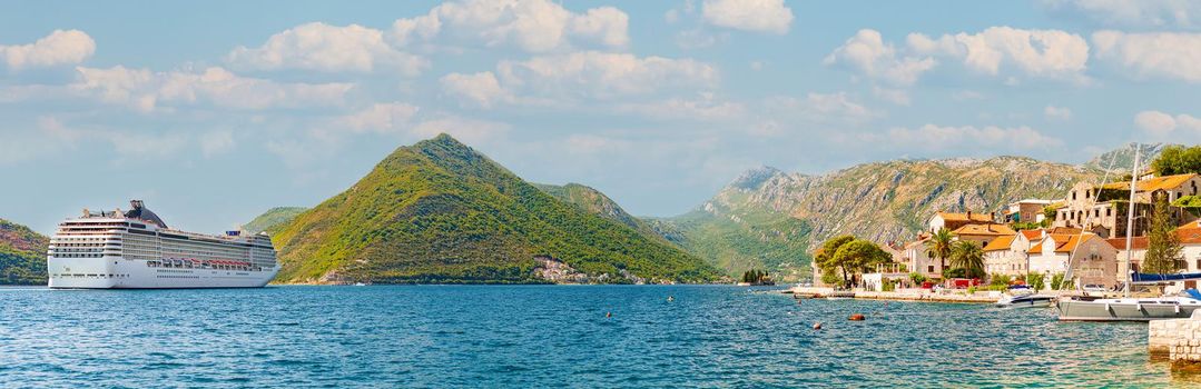 Perast bay, city and mountain views, Montenegro. Sunset scene with cloudy sky at scenic destination in Balcans, Europe.