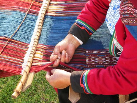 Close up of Peruvian lady in authentic dress spinning yarn by hand. (Peru)