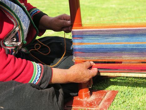 Close up of Peruvian lady in authentic dress spinning yarn by hand. (Peru)