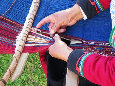 Close up of Peruvian lady in authentic dress spinning yarn by hand. (Peru)