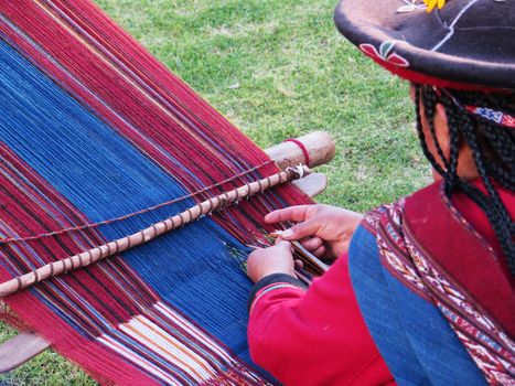 Close up of Peruvian lady in authentic dress spinning yarn by hand. (Peru)