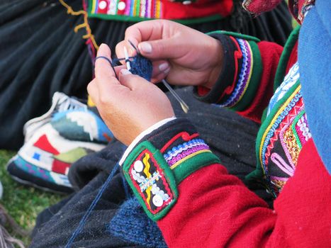 Close up of Peruvian lady in authentic dress spinning yarn by hand. (Peru)