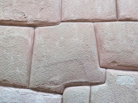 Inca wall made of natural volcanic stones, perfectly shaped, heritage of Inca history and architecture in Cusco, Peru.