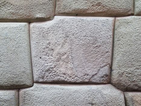 Inca wall made of natural volcanic stones, perfectly shaped, heritage of Inca history and architecture in Cusco, Peru.