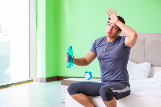 Young handsome man doing morning exercises in the hotel room