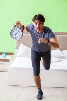 Young handsome man doing morning exercises in the hotel room