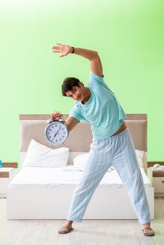 Young man in pajamas doing morning exercises 