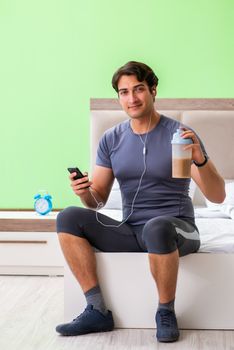 Young handsome man doing morning exercises in the hotel room