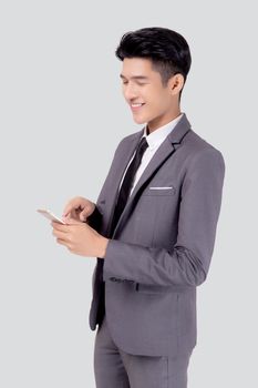 Portrait young asian business man in suit standing using smartphone to internet isolated on white background, businessman confident touch screen mobile phone with success, communication concept.