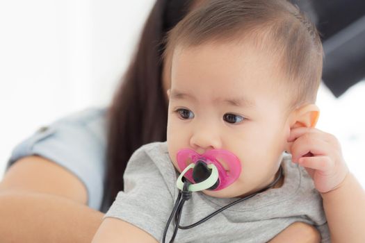 Closeup portrait of asian newborn, happiness face little baby girl with innocent, eyes of infant with feeling positive and cheerful, health and care, childcare and cozy.