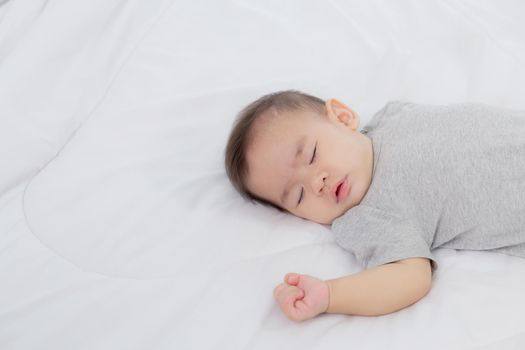 Portrait of asian little baby girl sleeping on bed in the bedroom at home, newborn napping with cozy and relax, infant innocence in bedtime, happy toddler cute, growth of child and emotion, indoors.