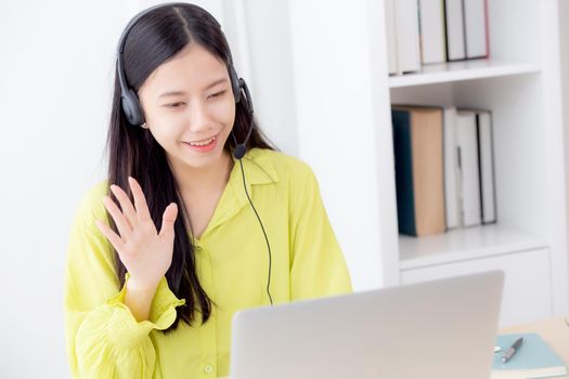 Young asian business woman using laptop computer for video conference online with social distancing, businesswoman working with video call, new normal, communication and work from home concept.