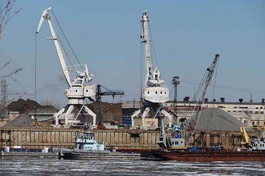 The river port. Special equipment and water transport in the port. Port crane, sand mining. High quality photo