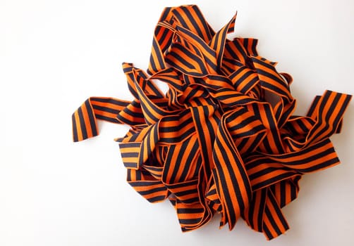 The St. George ribbon-a symbol of Russian military valor-is lying in a pile on a white background. Space for text.