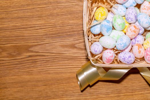 easter colorful eggs in a nest close up on a wooden background. High quality photo