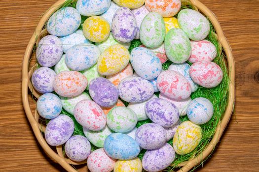 easter colorful eggs in a nest close up on a wooden background. High quality photo