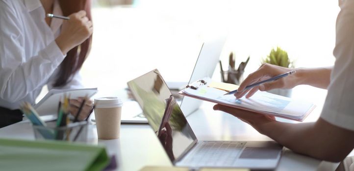 Team Businessman holding pencil working on financial report and business woman holding pens and holding paper in office..