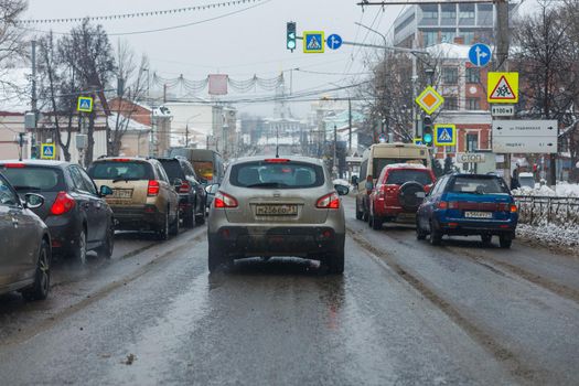 Tula, Russia - February 21, 2021: Cars stopped on crossroads traffic lights at winter day on main city street.