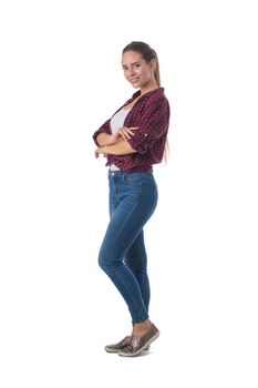 Full length portrait of smiling young woman with her arms folded isolated on white background, casual people