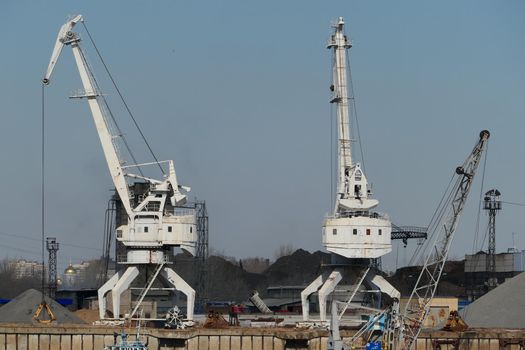 The river port. Sand mining and loading by port cranes. High quality photo