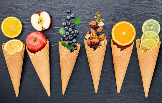 Various of ingredient for ice cream flavor in cones  set up on dark stone background . 