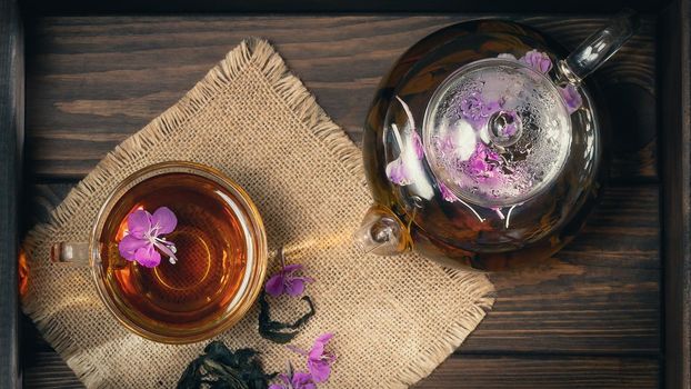 Herbal tea made from fireweed known as blooming sally in teapot and cup, top view.