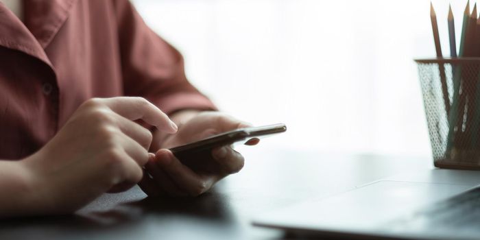 Close up hand of woman using smart phone.