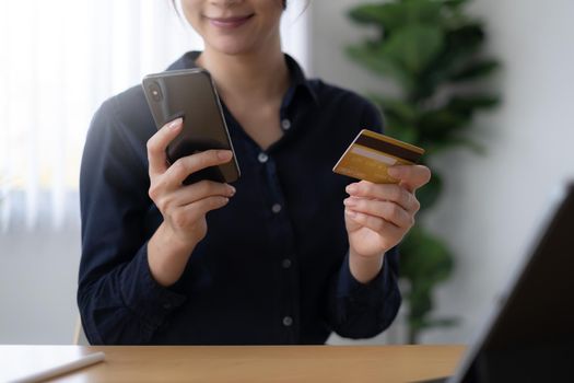 Mobile banking. Woman using online banking with credit card on mobile phone. Digital and internet payments shopping on network