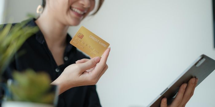 Mobile banking. Woman using online banking with credit card on tablet. Digital and internet payments shopping on network