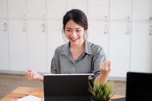 Successful young asian business woman with arms up, work from home concept