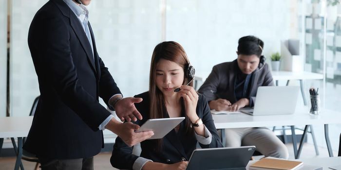 Female operator discussing with her team before communicates with the client