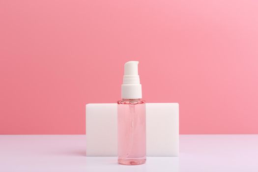 Cleansing and soothing foam or gel for face washing on white table against pink background with copy space. Concept of beauty products for daily skin care or anti acne treatment