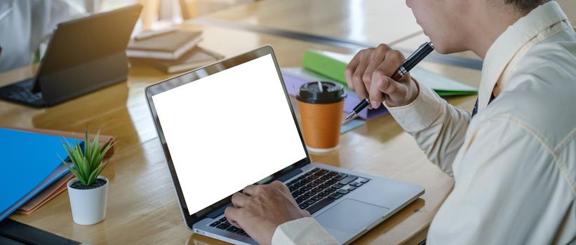 Close up hand of business man with digital tablet with blank screen on wooden desk