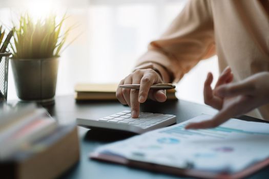 businessman working on desk office with using a calculator to calculate the numbers, finance accounting concept