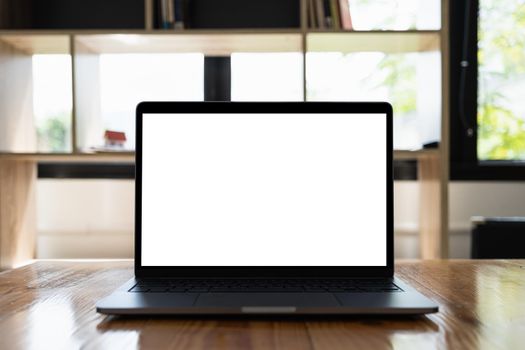 Laptop computer mockup and blank screen on wooden table with morning light