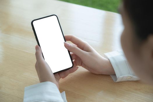 Asian woman holding smartphone with blank screen frameless modern design. Technology concept