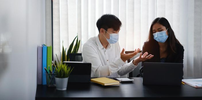 Businessman and team wear mask and try to explain about his work at home office. Work from home concept