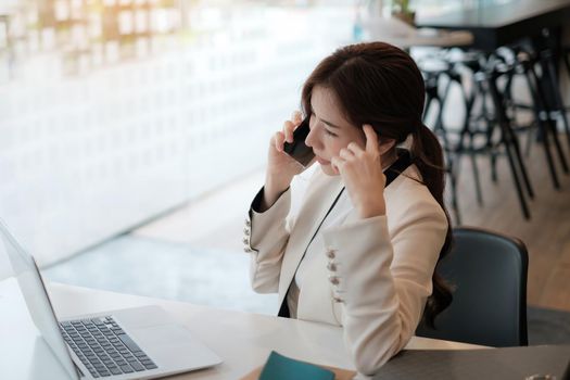 Business coffee shop owner talking with customer and telling cafe is back to open now and safe after covid-19 have vaccine. Female take the phone and make ads on laptop