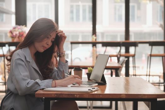 Business woman busy calculating finances or taxes on calculator. Work From Home concept