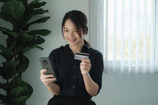 Mobile banking. Woman using online banking with credit card on mobile phone. Digital and internet payments shopping on network