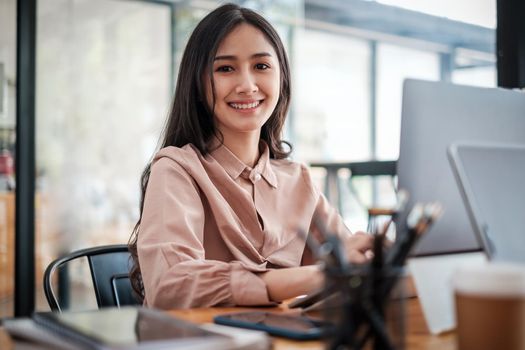 Young Pretty business woman smiling and sitting at home office. work from home concept