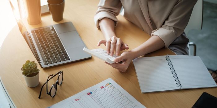 Business woman using a calculator to calculate working on desk in home office. Consultant,Financial Consultant,Financial advisor and accounting concept