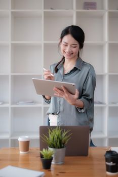 Portrait of Asian Business woman working with tablet in office. Work from home concept