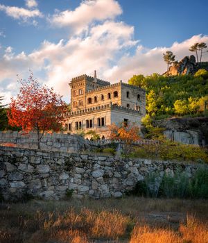 Abandoned ruin building of Termas Radium Hotel Serra da Pena in Sortelha with beautoful colorful trees at sunset, Portugal