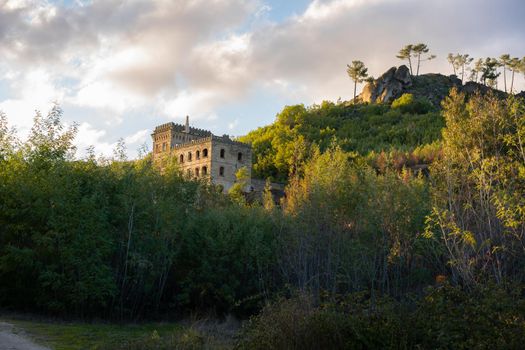 Abandoned ruin building of Termas Radium Hotel Serra da Pena in Sortelha with beautoful colorful trees at sunset, Portugal