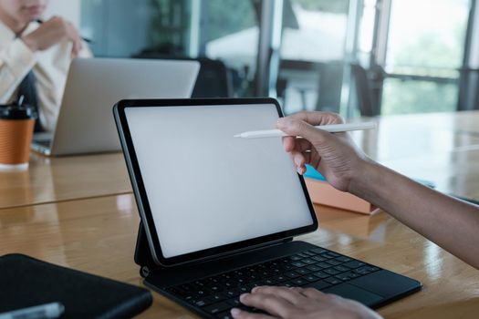 Close up hand of businesswoman with digital tablet with blank screen on wooden desk