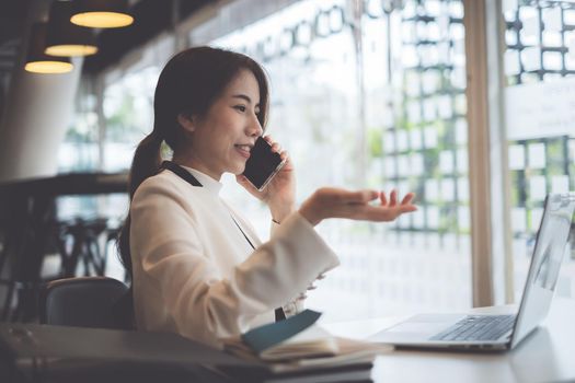 Business coffee shop owner talking with customer and telling cafe is back to open now and safe after covid-19 have vaccine. Female take the phone and make ads on laptop