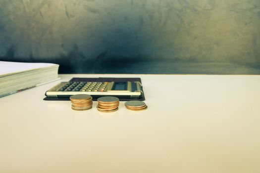 coin money and calculator old, book over white and black background with copy space add text. color vintage style tone