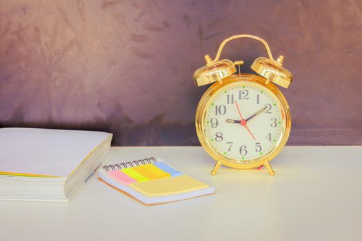 alarm clock old vintage gold and book over white on black background. with copy space add text. color cinematic Vintage style tone