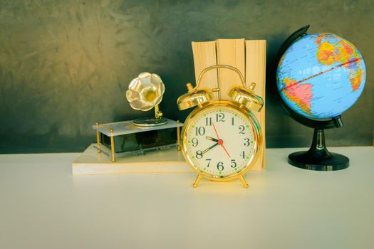 alarm clock old vintage gold and globe plastic - book,   gramophone over white on black background. with copy space add text. color cinematic Vintage style tone